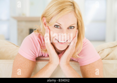 Woman sitting in living room smiling Stock Photo