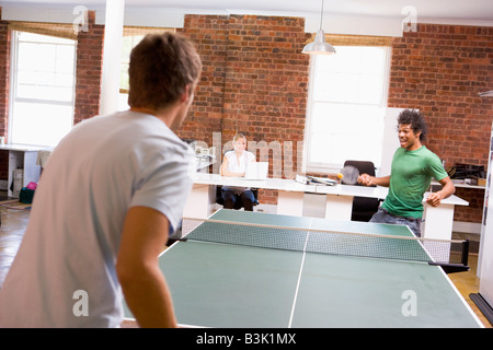 Two men in office space playing ping pong Stock Photo