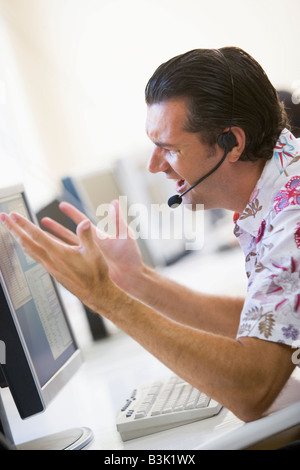 Man in computer room wearing headset looking frustrated Stock Photo