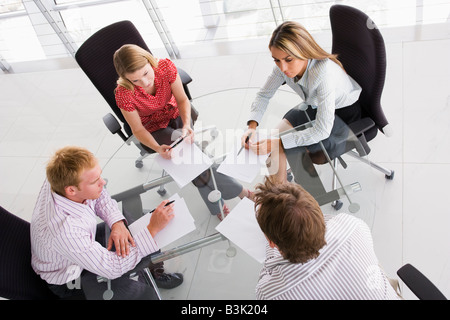 Four businesspeople in a boardroom with paperwork Stock Photo