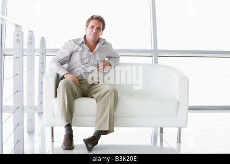 Businessman sitting in office lobby Stock Photo