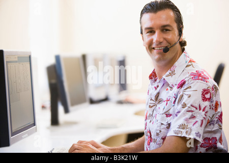 Man wearing headset in computer room smiling Stock Photo