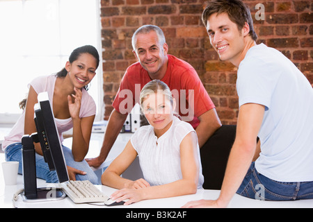 Four businesspeople in office space smiling Stock Photo