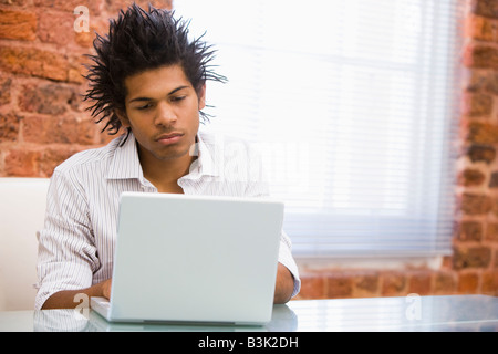 Businessman in office typing on laptop Stock Photo