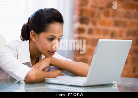 Businesswoman in office with laptop Stock Photo