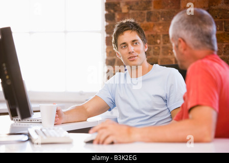 Two businessmen in office drinking coffee and talking Stock Photo