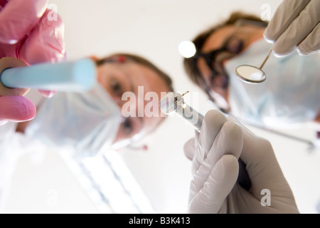 Dentist and assistant holding pick and mirror Stock Photo
