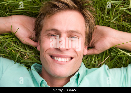 Man lying on grass smiling Stock Photo