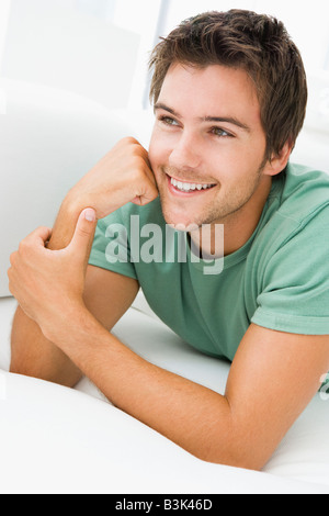 Man lying in living room smiling Stock Photo