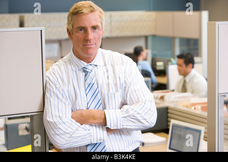 Businessman standing in cubicle Stock Photo