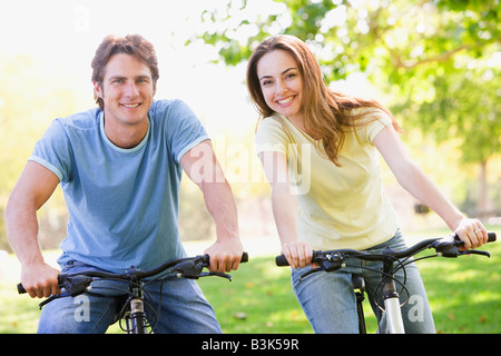 Couple on bikes outdoors smiling Stock Photo