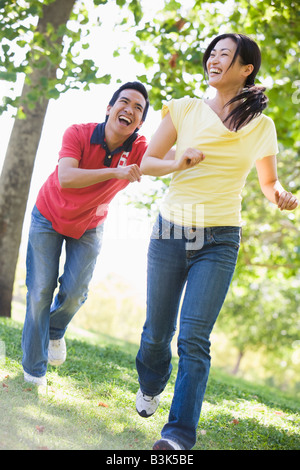 Couple running and being playful outdoors smiling Stock Photo