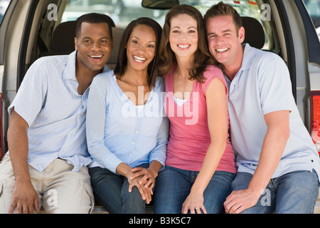 Two couples sitting in back of van smiling Stock Photo