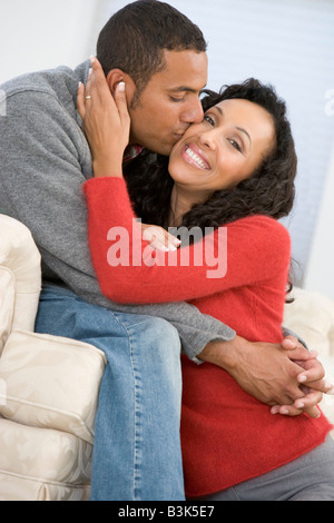 Couple in living room kissing and smiling Stock Photo