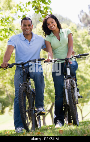 Couple on bikes outdoors smiling Stock Photo