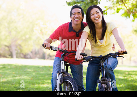 Couple on bikes outdoors smiling Stock Photo