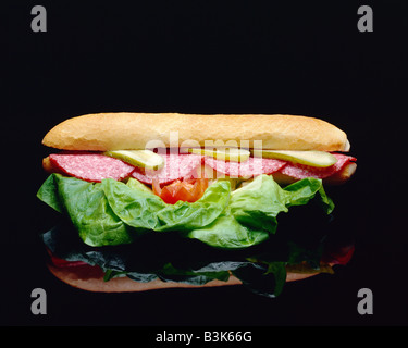 ONE SANDWICH WITH SALAMI SAUSAGE SLICES AND SALAD LEAVES Stock Photo
