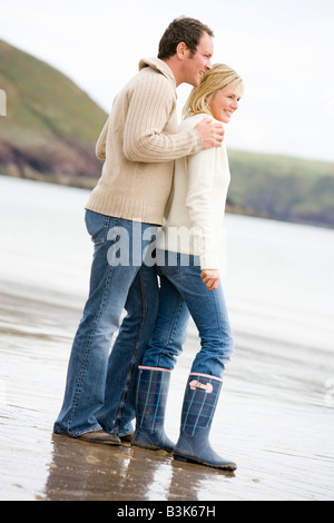 Couple standing on beach smiling Stock Photo