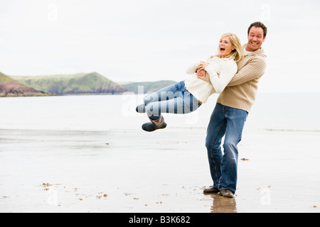 Couple playing on beach smiling Stock Photo
