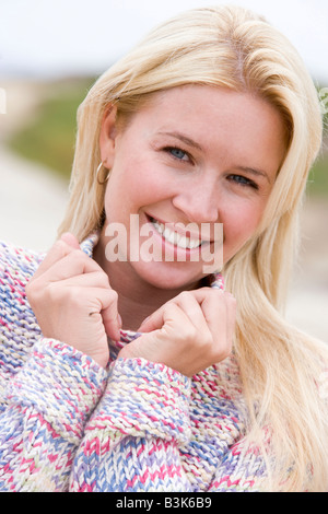Woman standing at beach smiling Stock Photo