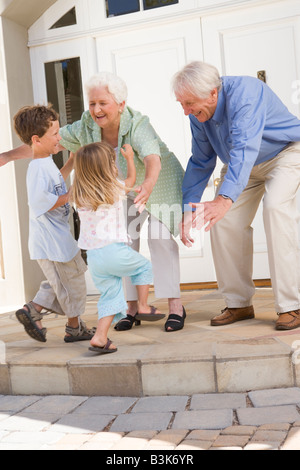 Grandparents welcoming grandchildren. Stock Photo