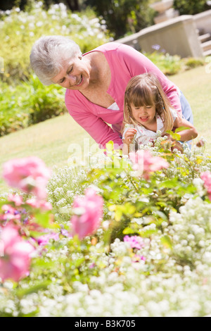 Grandmother and granddaughter outdoors in garden smiling Stock Photo