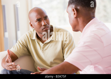 Two men in living room talking Stock Photo