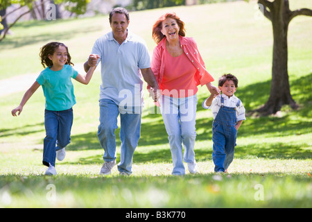 Grandparents running with grandchildren. Stock Photo