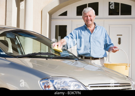 Senior man washing car outside his home Stock Photo