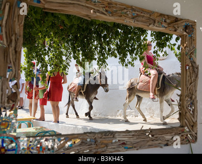 Mirror reflection of tourists riding donkeys, Lindos, Rhodes, Greece Stock Photo