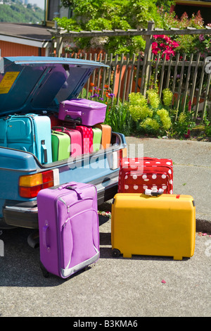 Car trunk loaded with colorful suitcases Stock Photo