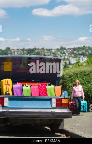 Car trunk loaded with colorful suitcases Stock Photo