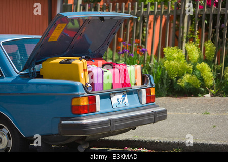 Car trunk loaded with colorful suitcases Stock Photo