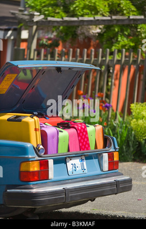 Car trunk loaded with colorful suitcases Stock Photo