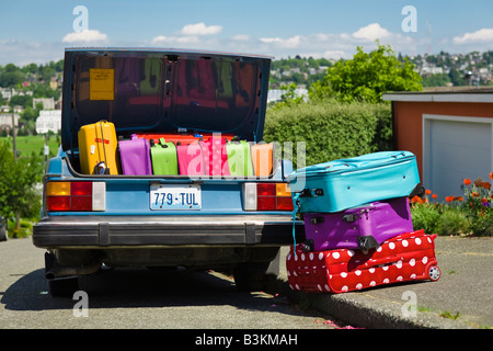 Car trunk loaded with colorful suitcases Stock Photo