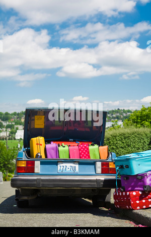 Car trunk loaded with colorful suitcases Stock Photo