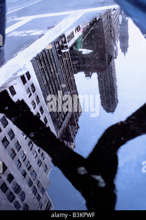 New York City Fifth Avenue man jumping over puddle on the street.  Manhattan skyline reflected. Stock Photo