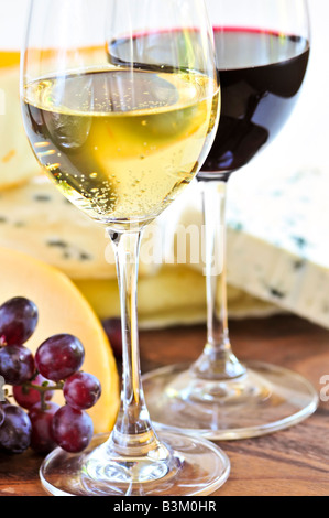 Wineglasses with red and white wine and assorted cheeses Stock Photo