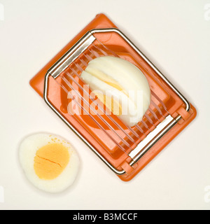 Boiled egg in egg slicer, elevated view Stock Photo