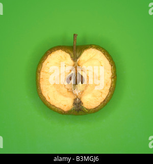 Rotting green apple cut in half, elevated view Stock Photo