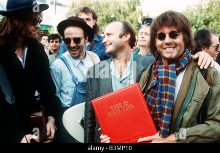 Michael Aspel TV Presenter surprises Phil Collins for the show This is your Life with Midge Ure Bob Geldof Stock Photo