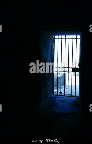 one secluded prison cell door in dark black room Stock Photo