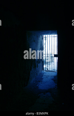 one secluded prison cell door in dark black room Stock Photo