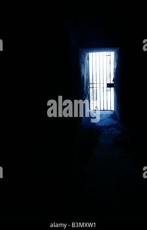 one secluded prison cell door in dark black room Stock Photo