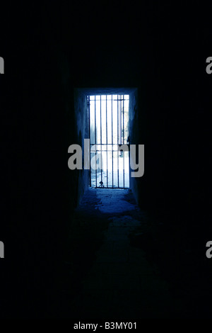 one secluded prison cell door in dark black room Stock Photo