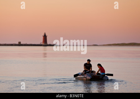 A young couple paddles across the Delaware Bay towards The Breakwater Lighthouse at Cape Henlopen State Park. Stock Photo