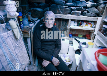 Tattooed hermit Tom Leppard (aka Leopard Man) comfortable in his secret makeshift underground hideaway shelter on Skye, Scotland Stock Photo