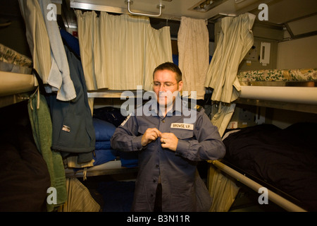 Able-bodied sailor gets dressed in his Junior Rating quarters aboard HMS Vigilant, a British Vanguard class nuclear submarine Stock Photo