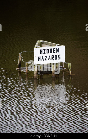 A sign in a quarry in County Durham, England, warns of deep water and hidden hazards. Stock Photo