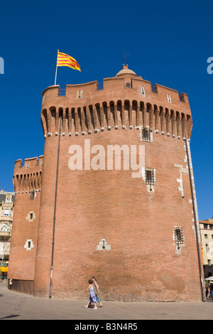 The Catalonian flag is blowing above the city gate 'Le Castillet'  in midtown Perpignan / Southern France Stock Photo